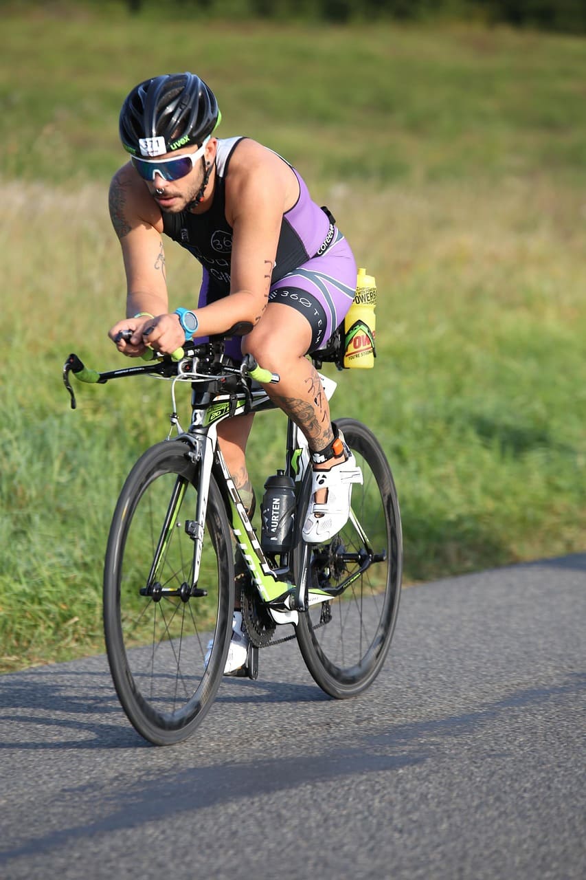 ciclista percorre una strada asfaltata vicino ad un prato