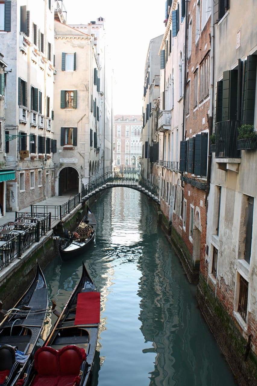 canale di Venezia con imbarcazioni tipiche ed un ponte sullo sfondo